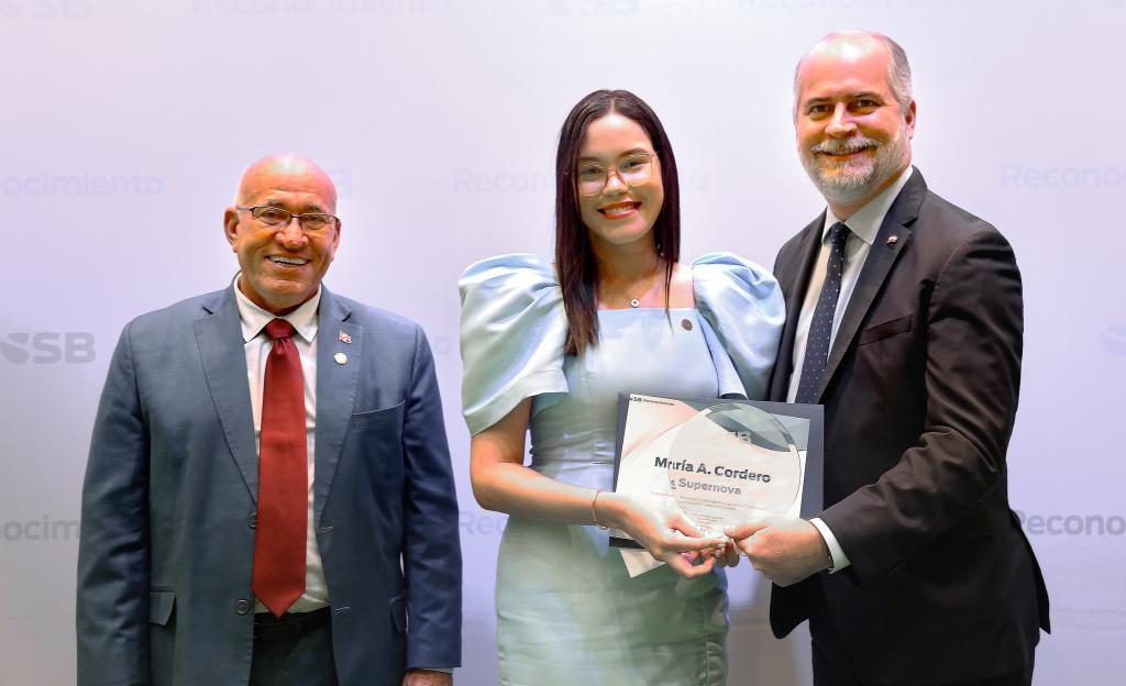 Superintendente y Intendente de Bancos entregando reconocimiento a colaboradora de la Superintendencia de Bancos